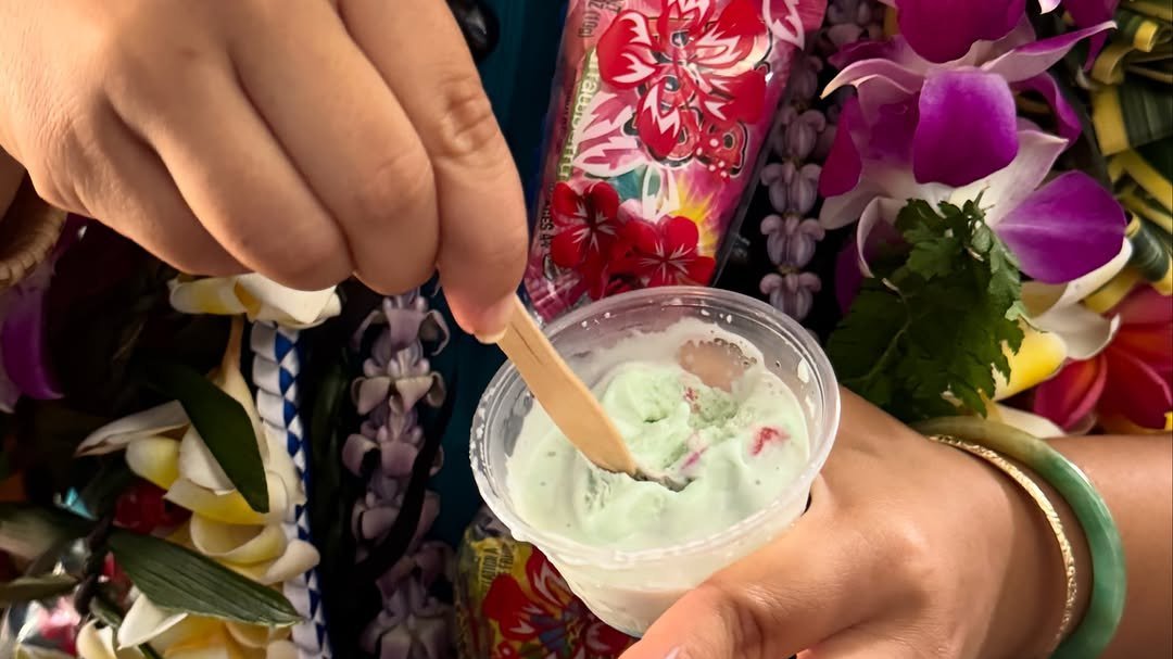 Aloha Ice Cream's cow-print cart and fringed umbrella set up outdoors at a Maui event